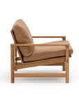 Side view of the Troubadour Lounge Chair | Leather • Light Oak by Wooden Stories, featuring tan leather cushions and a solid light oak frame with clean lines and minimalist, Danish-inspired design against a white background.