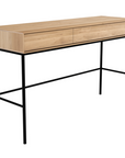 The Whitebird Desk - Oak by Ethnicraft features a minimalist design with solid European oak, two drawers, slim black metal legs, a light oak finish, and clean modern lines.