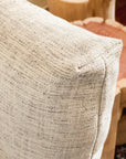 Close-up of a textured beige cushion with visible stitching on the SOBU Woody Sofa (One Arm) in White Ash and Fog, set before wooden furniture with natural, rounded forms.