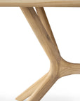 Close-up of the X Dining Table - Oak by Ethnicraft, showcasing its modern, branching wooden leg design crafted from smooth European oak, set against a plain white background.