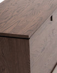 A close-up of the Wooden Stories Yorke Sideboard highlights its hinged lid, rectangular cutout handle, natural wood grain, and smooth Scandinavian-inspired finish.