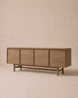 The Wooden Stories Yorke Sideboard, crafted from solid oak, stands against a neutral beige background. It showcases clean lines and a minimalist, mid-century modern look inspired by classic Scandinavian design, with four doors offering ample storage.