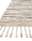 A close-up of the Loloi Khalid Rug in Natural/Ivory, featuring textured horizontal stripes and twisted fringe tassels along the edge, displayed against a white background.