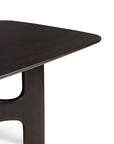 A corner of a dark Mahogany Rose Brown Ethnicraft Flow Dining Table, featuring a smooth, rounded edge and a wide, curved support leg.