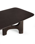 Ethnicraft Flow Coffee Table in Mahogany Rose Brown, a dark brown solid wood table featuring rounded corners and a sculptural, arched base.