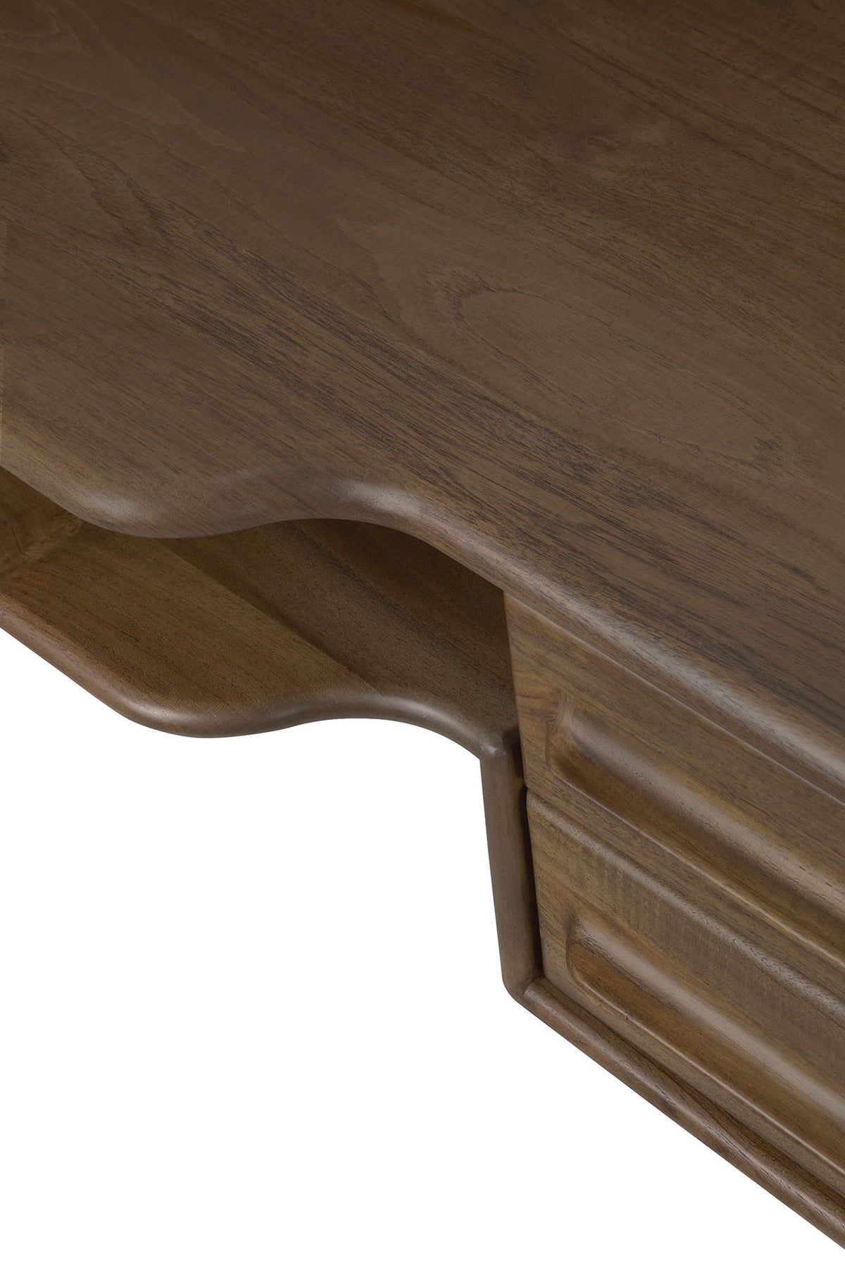 A close-up of the Flow Desk by Ethnicraft captures its smooth, curved corner and a portion of the drawer with a carved handle. Crafted from solid mahogany, this desk showcases a polished, rich brown finish—an elegant example of modern workspace furniture.