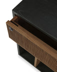 A close-up of the Ethnicraft Oscar Drawer Unit showcases its modern black cabinet design with an open solid teak drawer featuring vertical grooves and a keyhole on the left side—embodying timeless style that’s perfect for office storage.