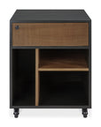 The Ethnicraft Oscar Drawer Unit is a modern piece in black and wood, featuring casters for mobility, a single textured solid teak drawer at the top, open office storage compartments below with a shelf divider.