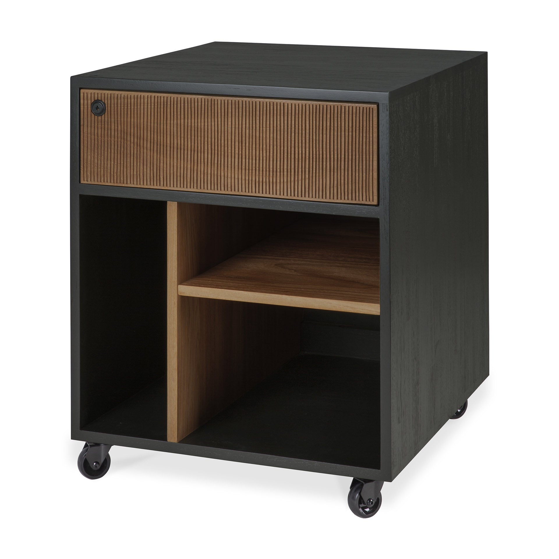 The Oscar Drawer Unit by Ethnicraft is a black rolling cabinet crafted with a solid teak wood drawer, styled with vertical grooves on the front. Inspired by classic design, it offers versatile office storage with open compartments below, divided by a shelf and partition for organized functionality.