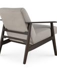 The Aspekt Lounge Chair by Ethnicraft features light gray upholstery, a dark brown teak frame, angled legs, and wide flat armrests for a stylish mid-century design, shown here from the back.