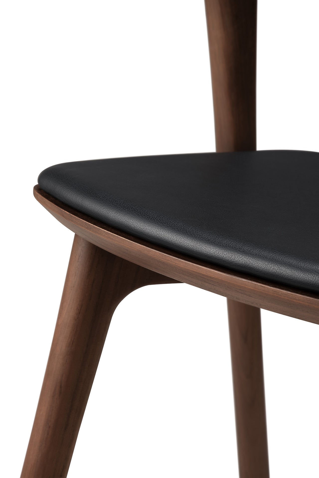 Close-up of the Ethnicraft Bok Dining Chair - Teak Brown, featuring solid teak construction, a triangular black leather seat cushion, and angled legs that highlight its smooth, minimalist design and craftsmanship.