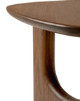 Close-up of the Ethnicraft Flow Side Table corner, featuring smooth, rounded edges and a curved leg that accentuates the natural grain and texture of its polished wood.