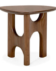 The Flow Side Table by Ethnicraft is a small wooden side table with three legs and a curved, geometric cutout design beneath its smooth, triangular tabletop, beautifully blending vintage modern aesthetics with timeless craftsmanship.