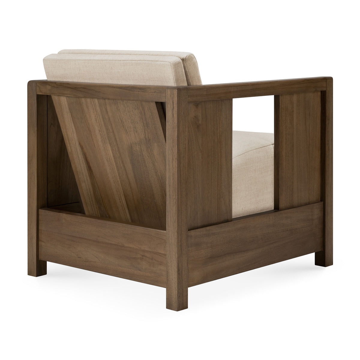A modern armchair with a solid teak frame and flax-colored cushioned seat and backrest, viewed from the back and side to highlight its angled support and open side panels—this Roan Lounge Chair | Flax by Ethnicraft blends timeless design with the lasting beauty of solid wood craftsmanship.