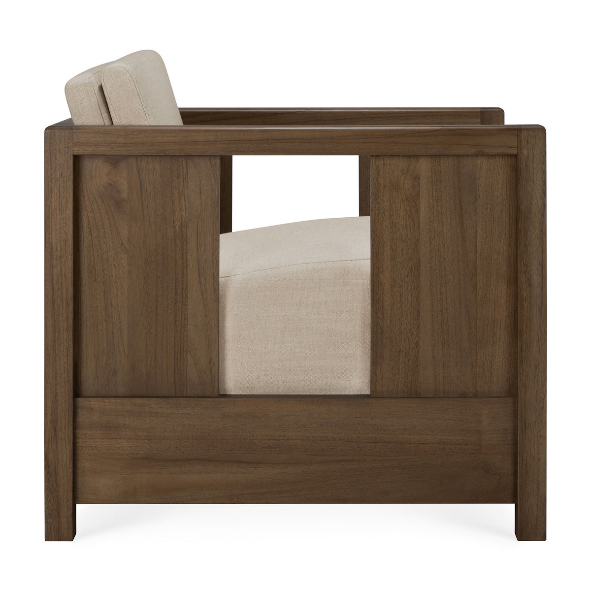 Side view of the Roan Lounge Chair | Flax by Ethnicraft, a modern armchair featuring a solid teak wooden frame and a beige upholstered seat and backrest. The chair showcases clean, straight lines and an open rectangular cutout in the wooden arm panel.