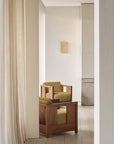 Minimalist room with neutral tones, featuring the Ethnicraft Roan Lounge Chair in Amber placed near sheer beige curtains. Light wood flooring and simple, textured walls complete the calm, modern aesthetic.