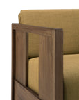 Close-up of the Roan Lounge Chair in Amber by Ethnicraft, showcasing its modern silhouette with an olive-green cushion and a wooden armrest featuring a rectangular open-frame design—an elegant detail characteristic of Ethnicraft’s refined style.