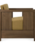 Side view of the Roan Lounge Chair | Amber by Ethnicraft, showcasing a solid teak frame and amber-hued cushions, with a distinctive rectangular cutout in the wooden armrest panel—a signature detail of Ethnicraft furniture.