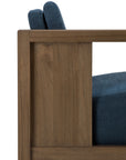 Close-up side view of the Ethnicraft Roan Lounge Chair | Ink, featuring blue upholstered seat and back cushions on a sleek wooden frame that highlights the chair’s modern design, wood grain detailing, and vintage-inspired charm.