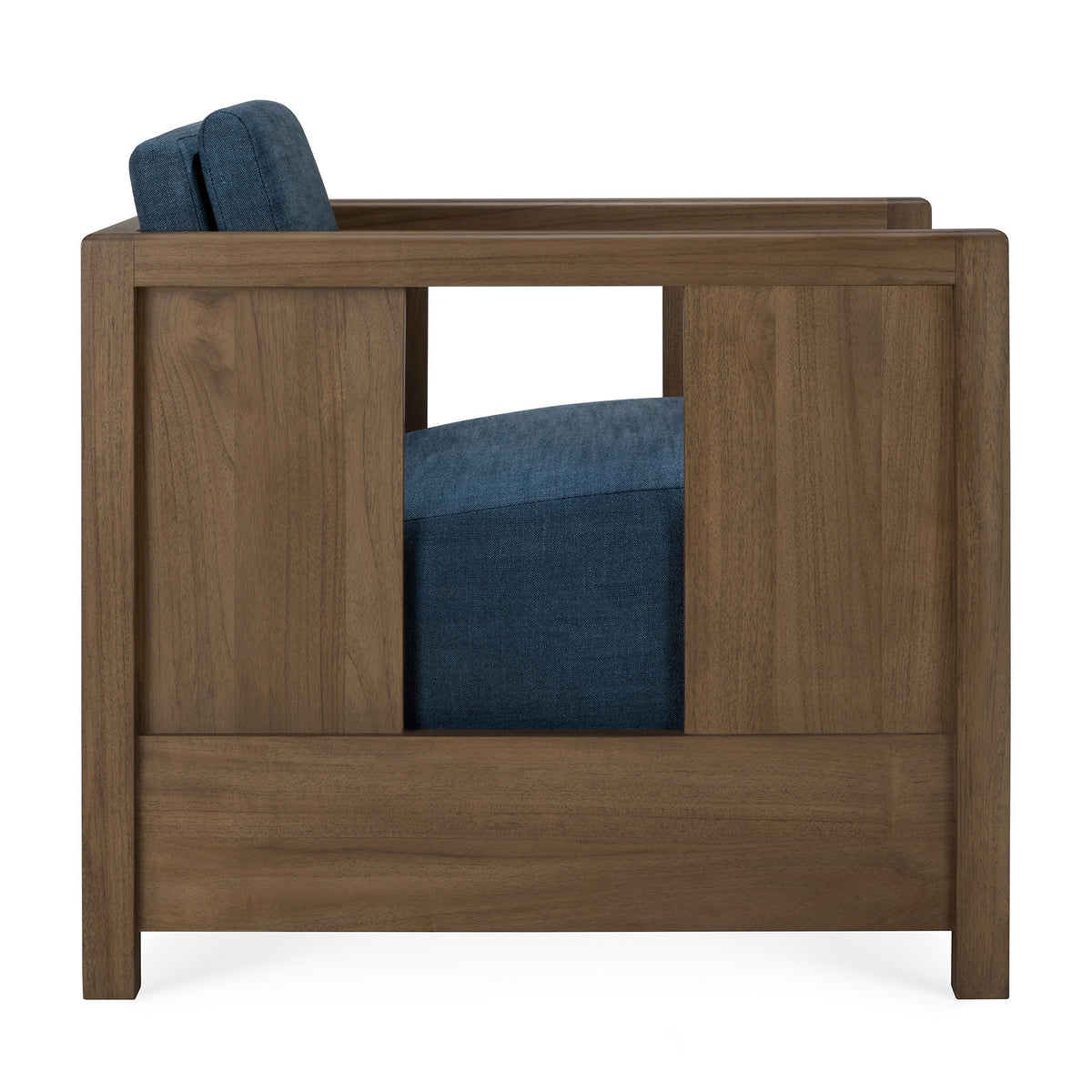 Side view of the Ethnicraft Roan Lounge Chair | Ink, a vintage-inspired chair with a modern, boxy wooden frame and dark blue upholstered seat and back cushions. The design features a rectangular cutout in the wooden side panel.