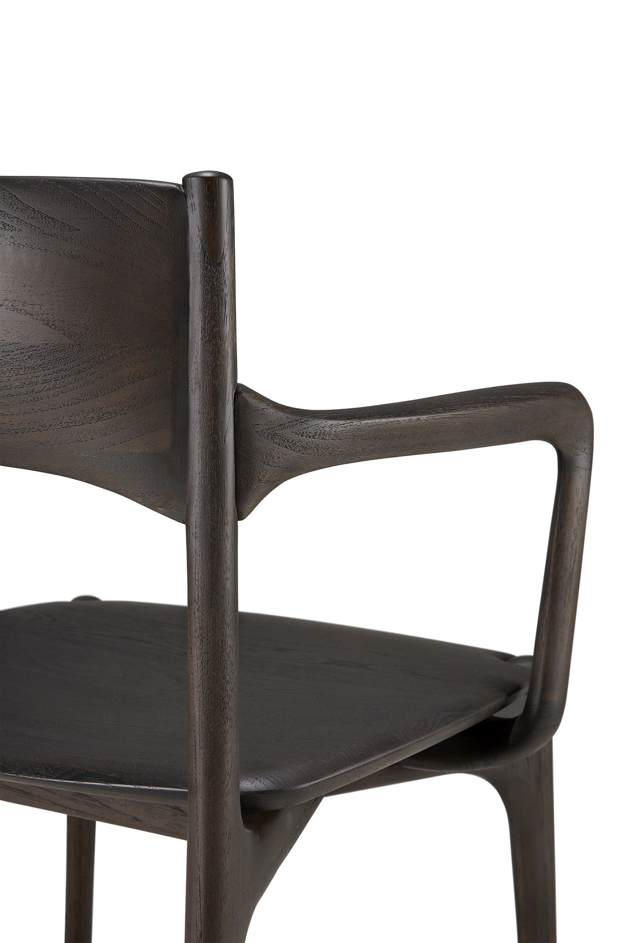 A close-up of Ethnicraft's PI Dining Chair - Teak Dark Brown with arms, highlighting its curved backrest, angled armrests, and contoured seat—modern handcrafted furniture displayed against a white background.