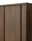 Close-up of the top corner of Ethnicraft's Pillar Sideboard - Teak Wild Brown, highlighting its smooth finish, vertical panel details, and the natural brown teak wood with visible grain patterns.