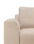 Close-up of the left armrest and seat of the Ethnicraft Ease Lounge Chair, showcasing its textured upholstery, high density foam, and clean modern lines against a white background.