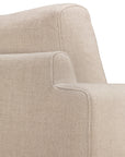 Close-up of the Ethnicraft Ease Lounge Chair in beige upholstery, showcasing high density foam for comfort and emphasizing the clean lines and soft texture of its armrest and backrest against a white background.