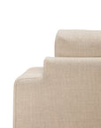 Close-up of the back and armrest of the beige Ease Lounge Chair by Ethnicraft, showcasing its textured fabric, high-density foam, and minimalist modern design against a white background.