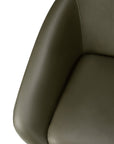 Close-up of a green leather Ethnicraft Barrow Lounge Chair - Green Leather with curved armrests and a cushioned seat.