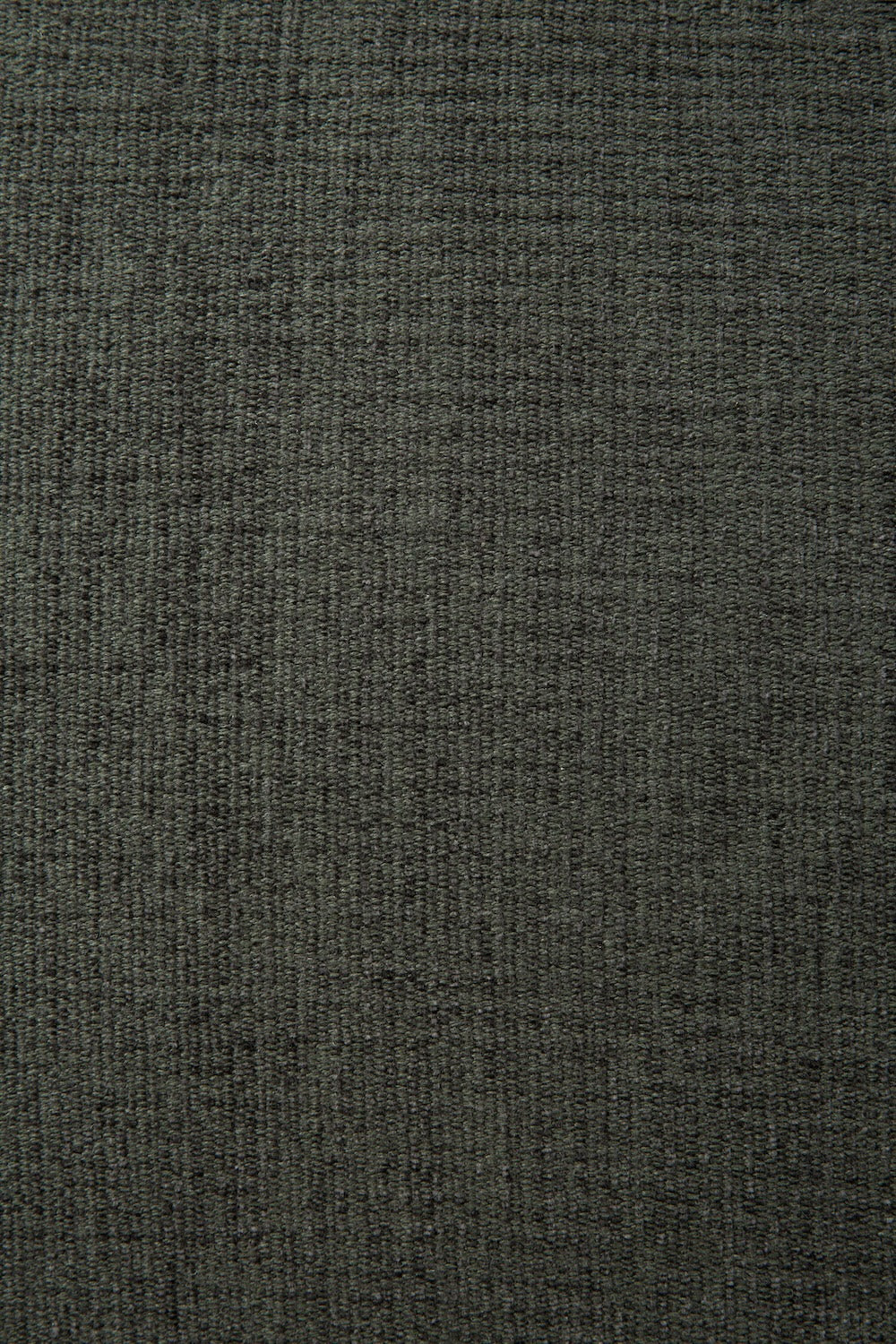 Close-up of a dark, textured fabric surface with a subtle grid-like woven pattern, reminiscent of the high-performance stain-resistant Eco Fabric featured on the Ethnicraft N701 Modular Sofa - Moss. The material appears soft and slightly variegated in color, lending it a natural, organic appearance.