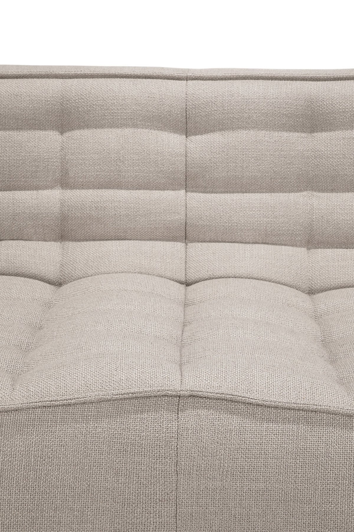 Close-up of the Ethnicraft N701 2-Seater Sofa in beige, featuring a tufted fabric upholstery with a textured surface and horizontal stitching on the backrest and seat, exemplifying exceptional European craftsmanship.