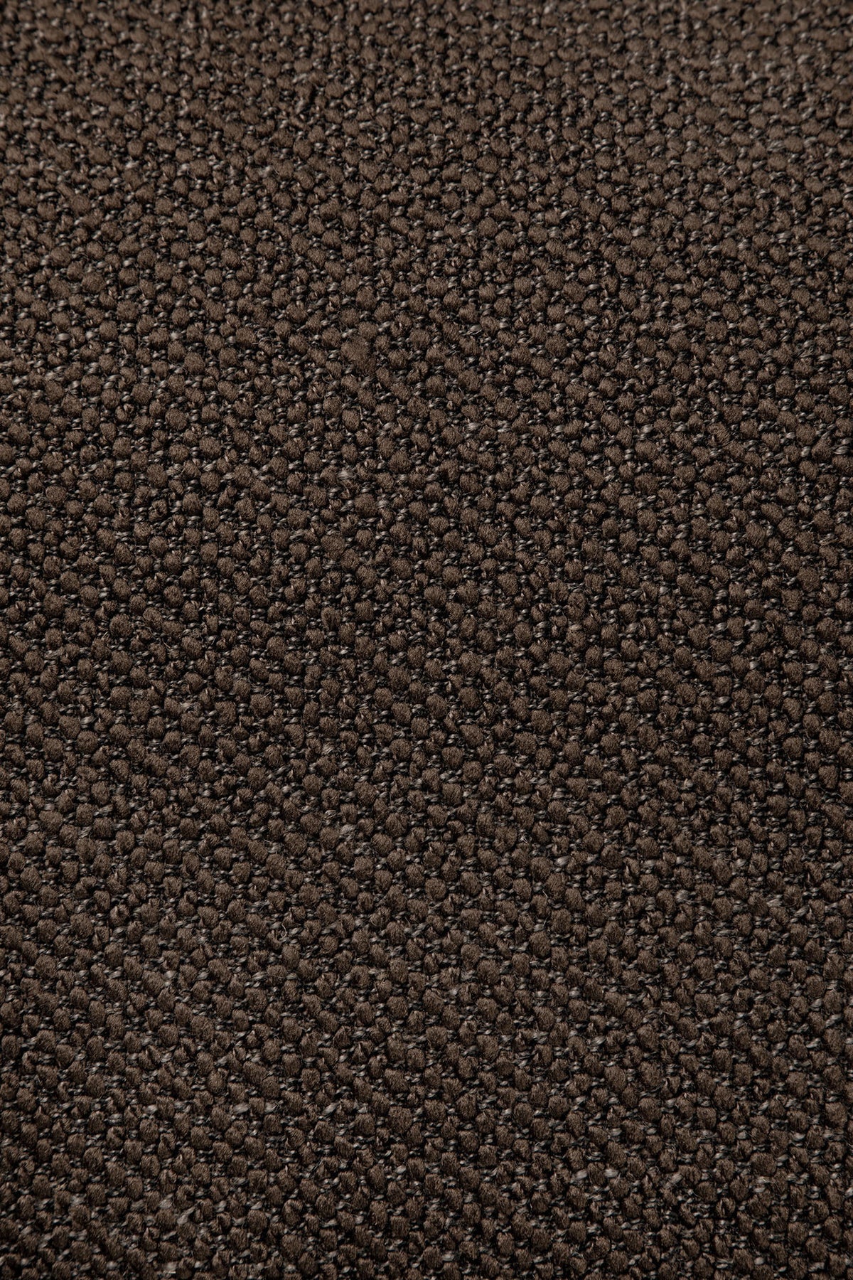 Close-up of a brown textured surface, possibly leather or synthetic material, featuring a fine, pebbled pattern—evocative of the sophisticated finishes found on the Ethnicraft Figur Sofa | 3 Seater, ideal for modern living spaces.