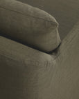 Close-up of the corner of Ethnicraft's Weave Lounge Chair in green, showing the textured fabric and cushion edge, highlighting the brand's signature style.