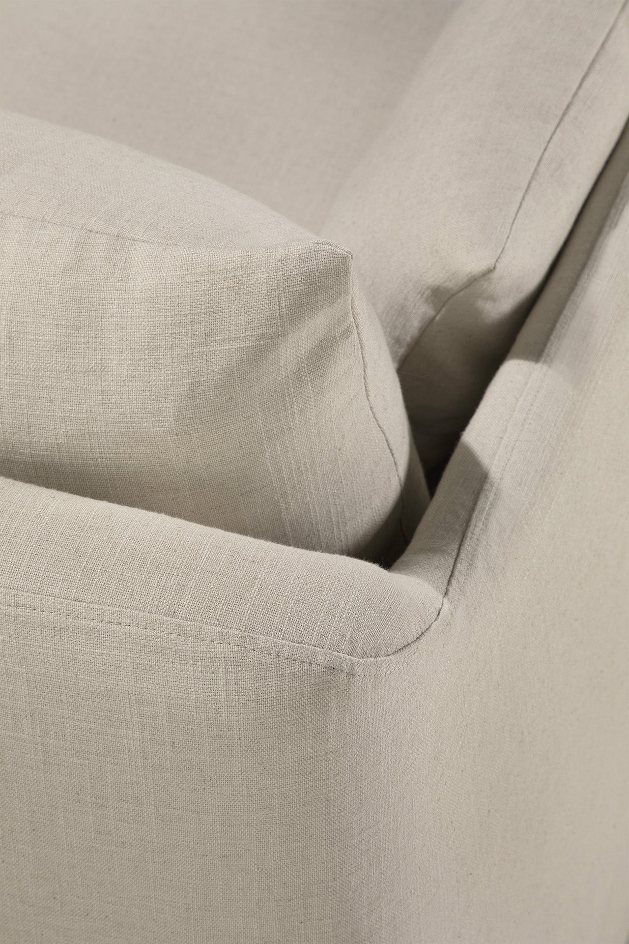 Close-up of the Weave sofa - Bone by Ethnicraft, showcasing its textured linen blend upholstery in beige with a neatly fitted cushion for a relaxed, inviting look.