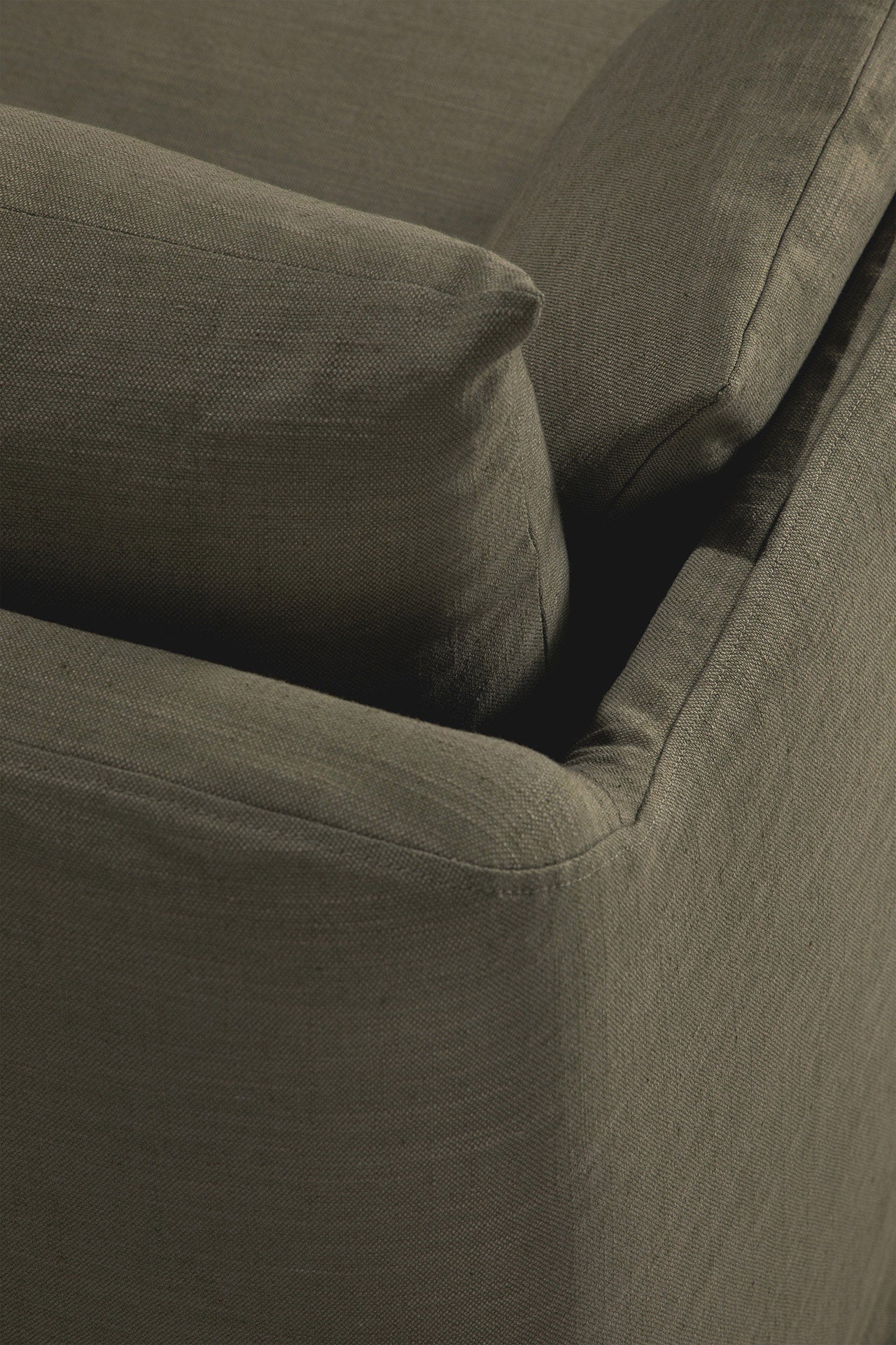 Close-up of the corner of the Ethnicraft Weave Sofa in green, showcasing its linen blend upholstery and textured seams for a relaxed, stylish look.