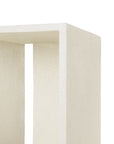 Close-up of the corner of Ethnicraft’s Elements Bedside Table, showcasing its minimalist off-white rectangular form, geometric open design, and microcement-textured surface.