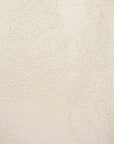 Close-up of a textured, off-white plaster wall with a subtly rough, grainy finish reminiscent of microcement, inspired by the Elements Bedside Table from Ethnicraft.