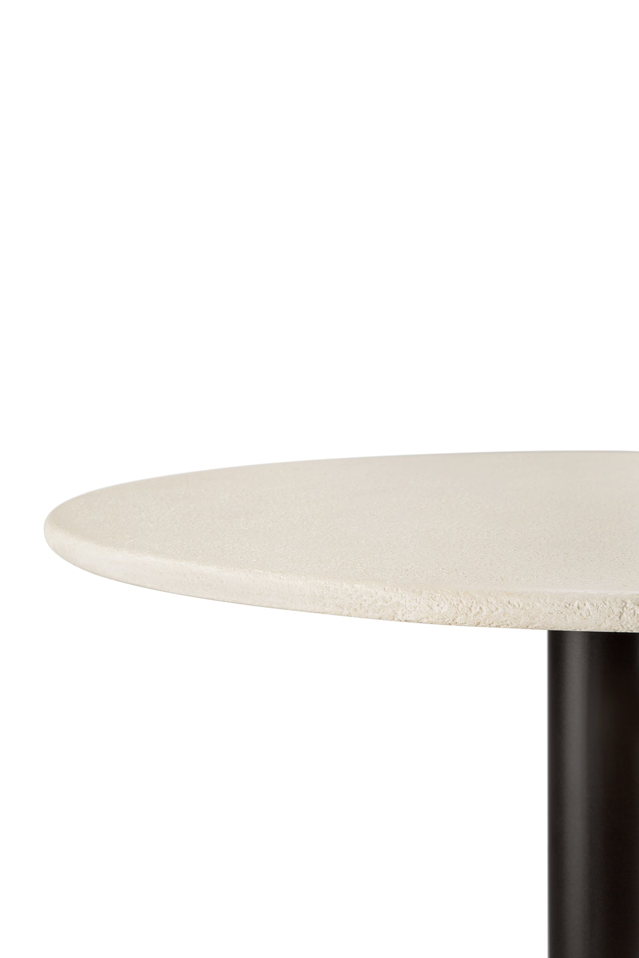 A close-up shows the smooth, light-toned microcement tabletop of the Ethnicraft Blend Dining Table, featuring its round surface and a dark cylindrical base against a white background.