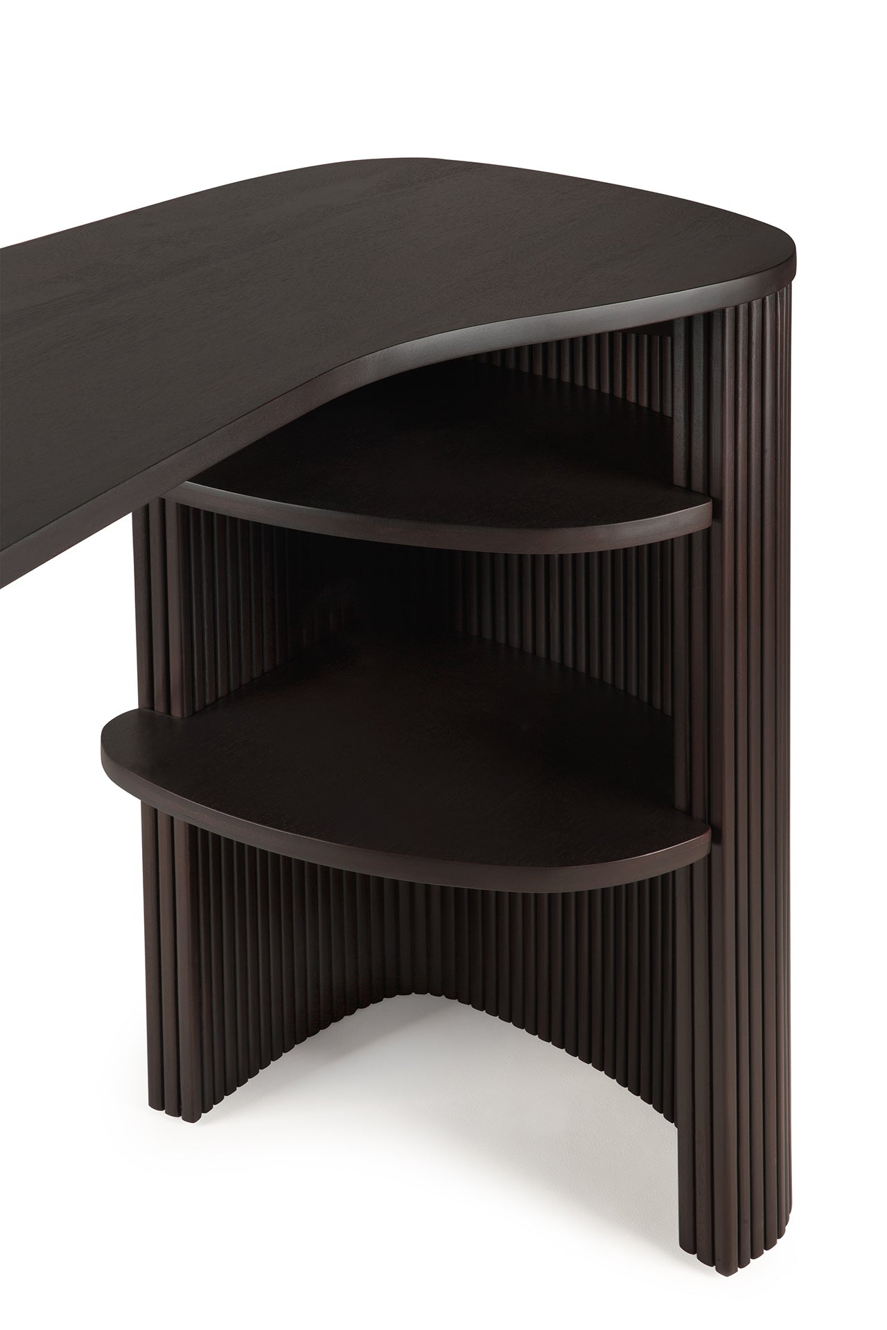The Ethnicraft Roller Max Desk is a dark wood mahogany piece with a curved corner, two open rounded shelves, and vertical grooved detailing on the sides and front.