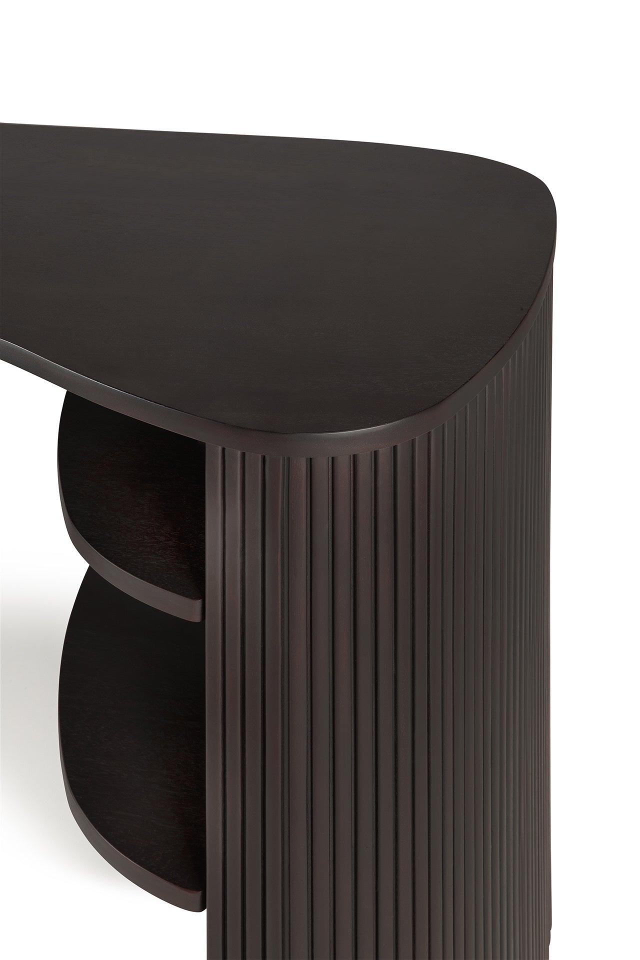 A close-up of the Ethnicraft Roller Max Desk shows its dark mahogany corner, rounded triangular top, vertical grooved side panel, and two curved shelves beneath, all set against a white background.