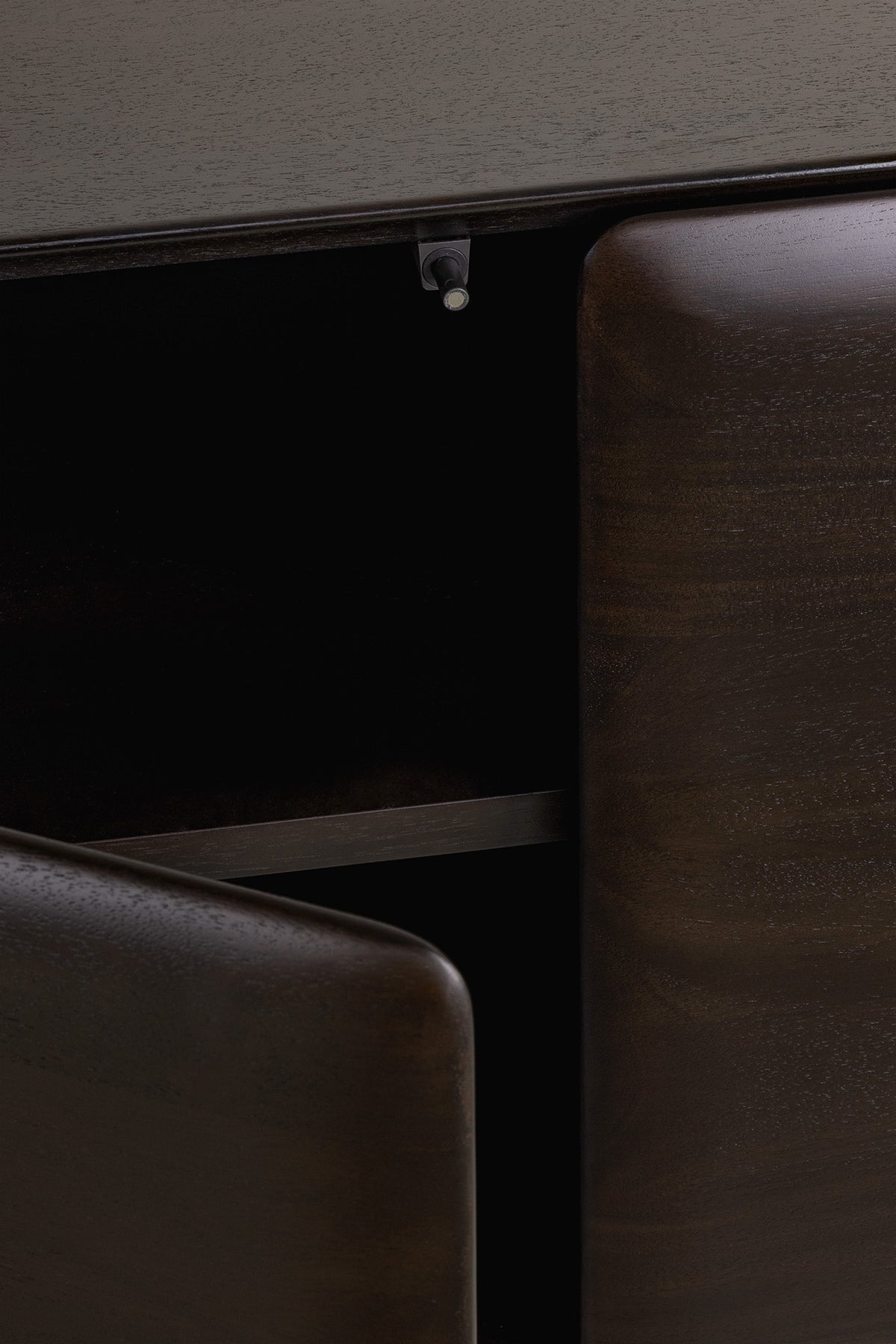 Close-up of a dark Ethnicraft PI Light hanging sideboard with a cabinet door slightly ajar, revealing an interior shelf and a small magnetic latch.