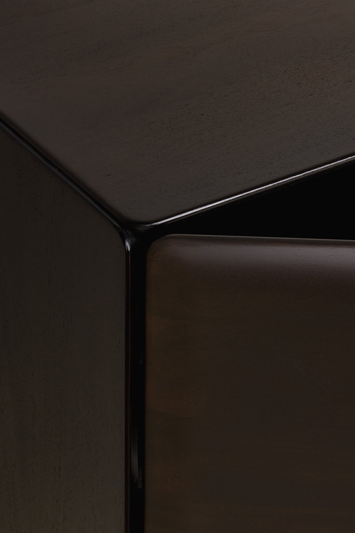 Close-up view of the corner of a dark mahogany PI Light Hanging Sideboard by Ethnicraft with a partially opened door.
