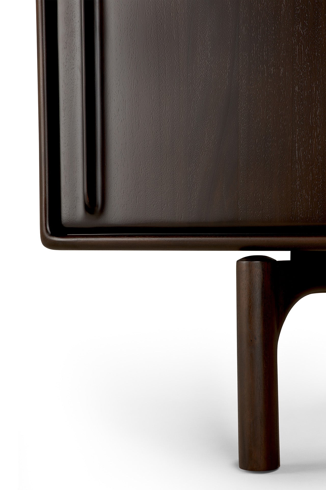 Close-up of the Flow Sideboard by Ethnicraft, featuring a dark wood finish, a vertical handle on the door, and a rounded leg beneath, set against a white background.