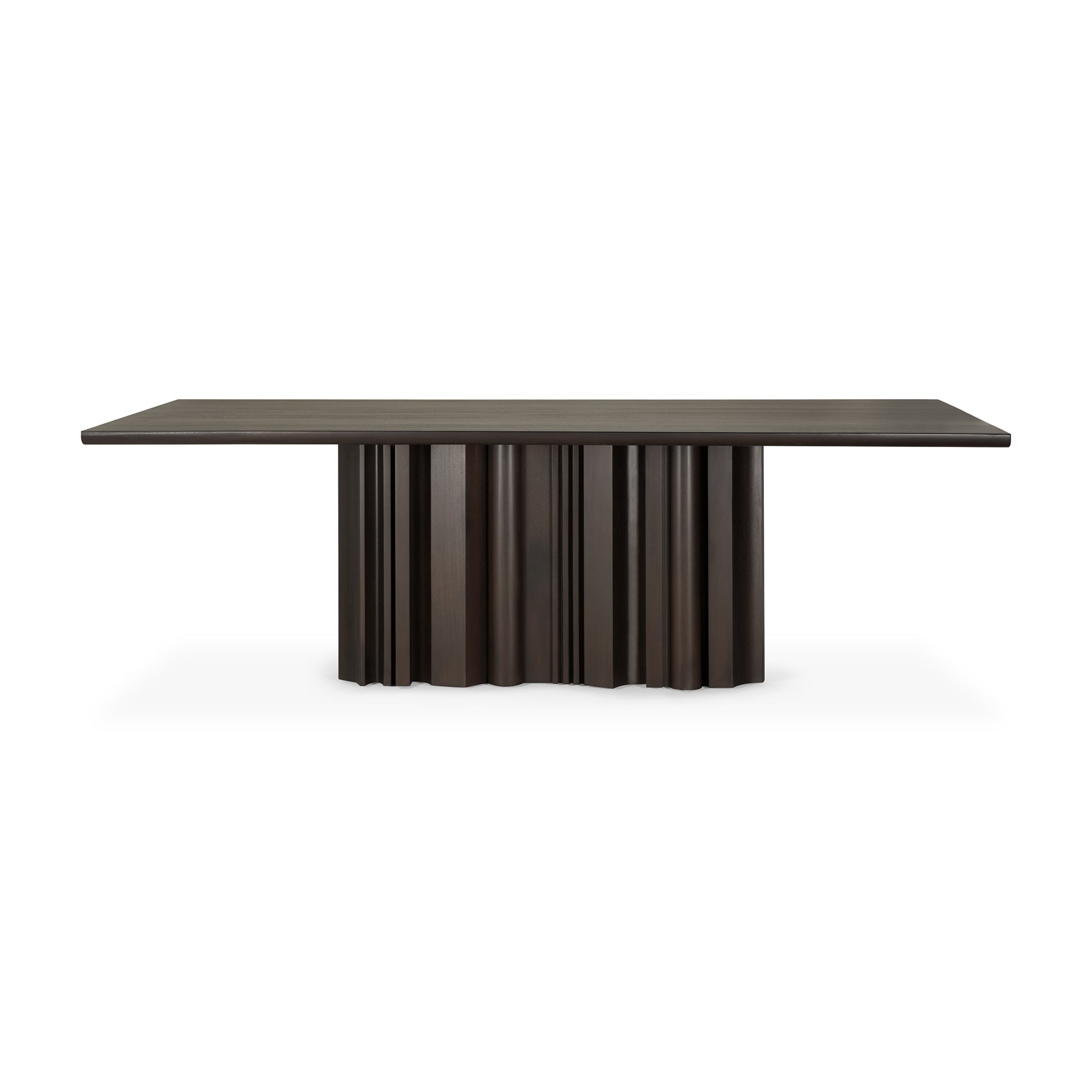 The Sequence Dining Table by Ethnicraft is crafted in dark brown mahogany with a flat top and a sculptural base featuring vertical ridges and a wavy design.