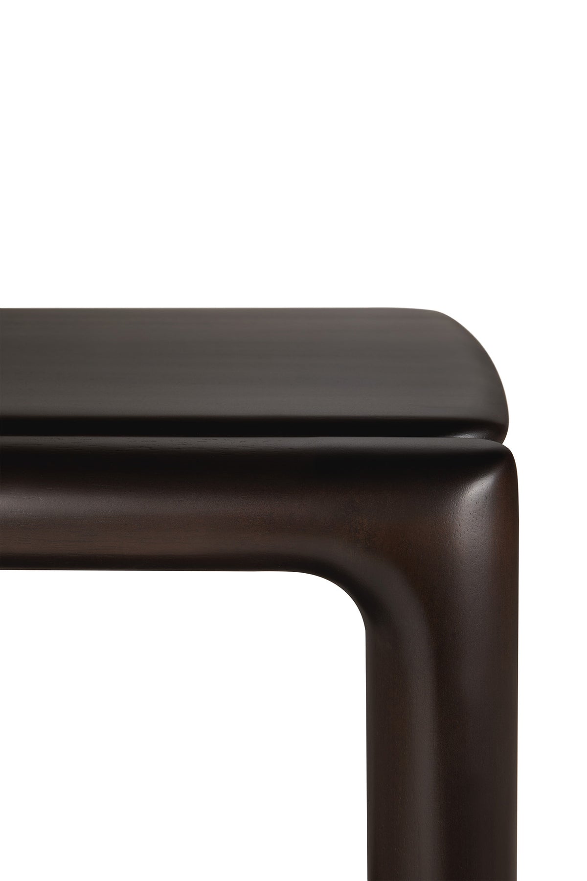 A close-up of the smooth, rounded corner of an Ethnicraft Eda Side Table in mahogany.