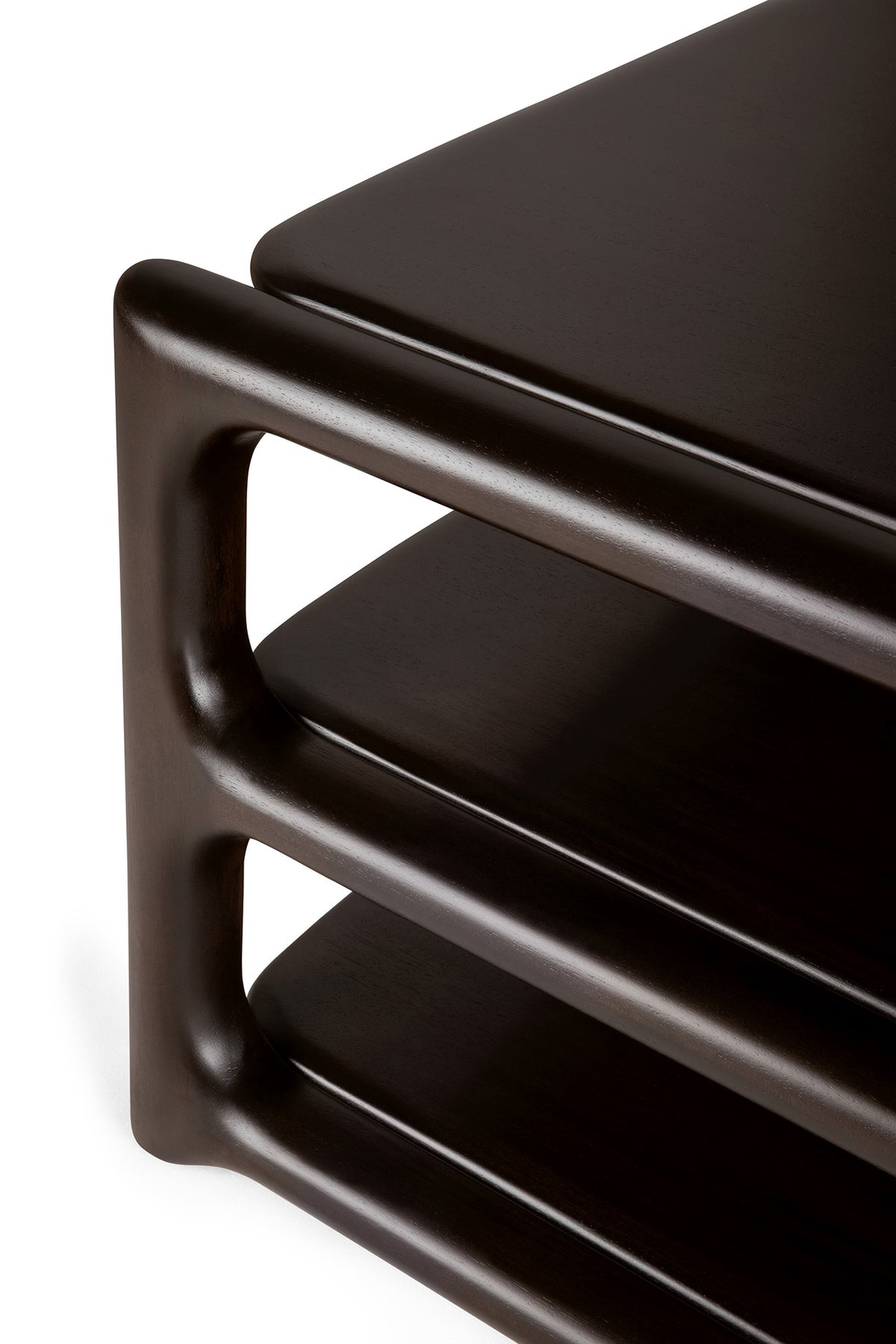 Close-up of the corner of the Ethnicraft Eda Coffee Table, crafted from dark wood with rounded edges and two open shelves, highlighting a smooth, modern design and heirloom-quality craftsmanship inspired by European traditions—an inviting piece that echoes the classic aesthetic of Ethnicraft tables.