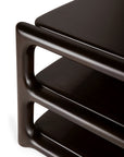 Close-up of the corner of the Ethnicraft Eda Coffee Table, crafted from dark wood with rounded edges and two open shelves, highlighting a smooth, modern design and heirloom-quality craftsmanship inspired by European traditions—an inviting piece that echoes the classic aesthetic of Ethnicraft tables.
