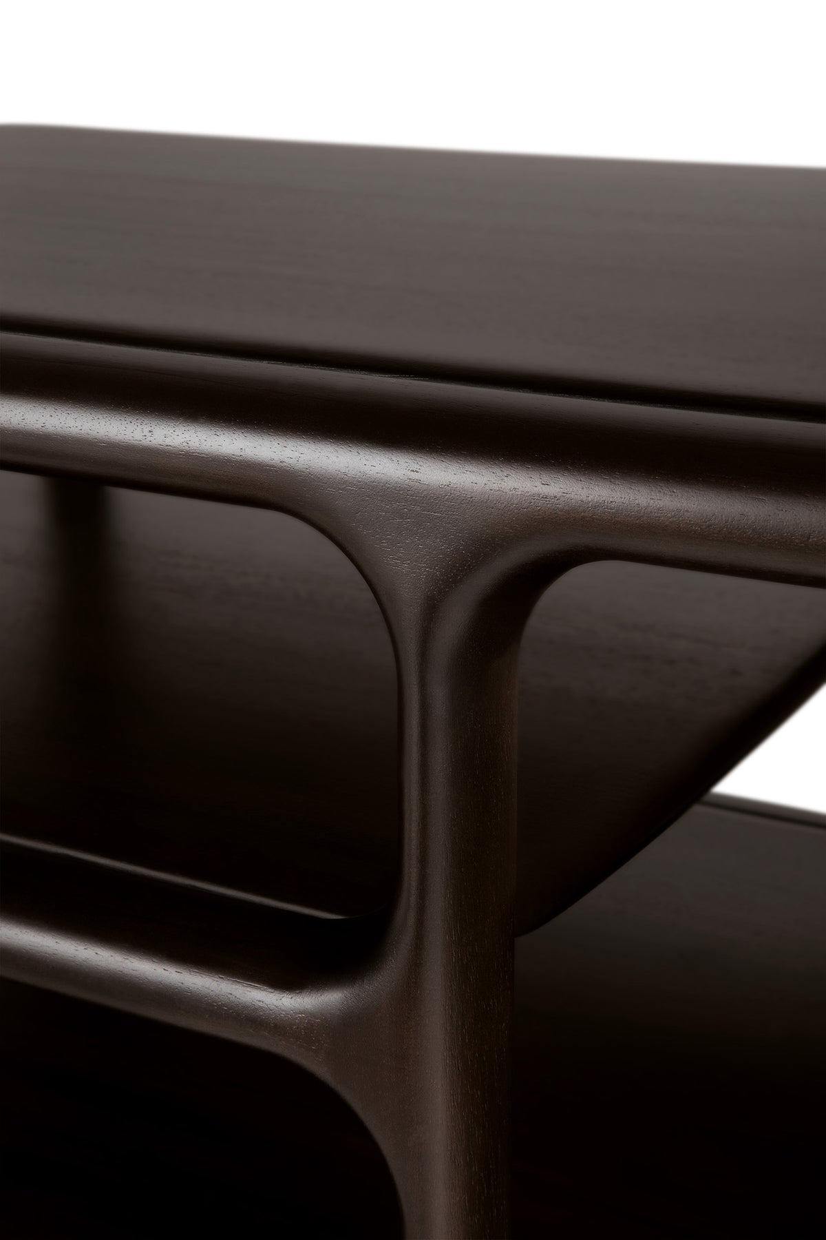Close-up of the Eda Coffee Table by Ethnicraft—a modern piece crafted in rich, dark wood with smooth, rounded edges and an integrated lower shelf, set against a white background—showcasing heirloom-quality furniture inspired by European craftsmanship.