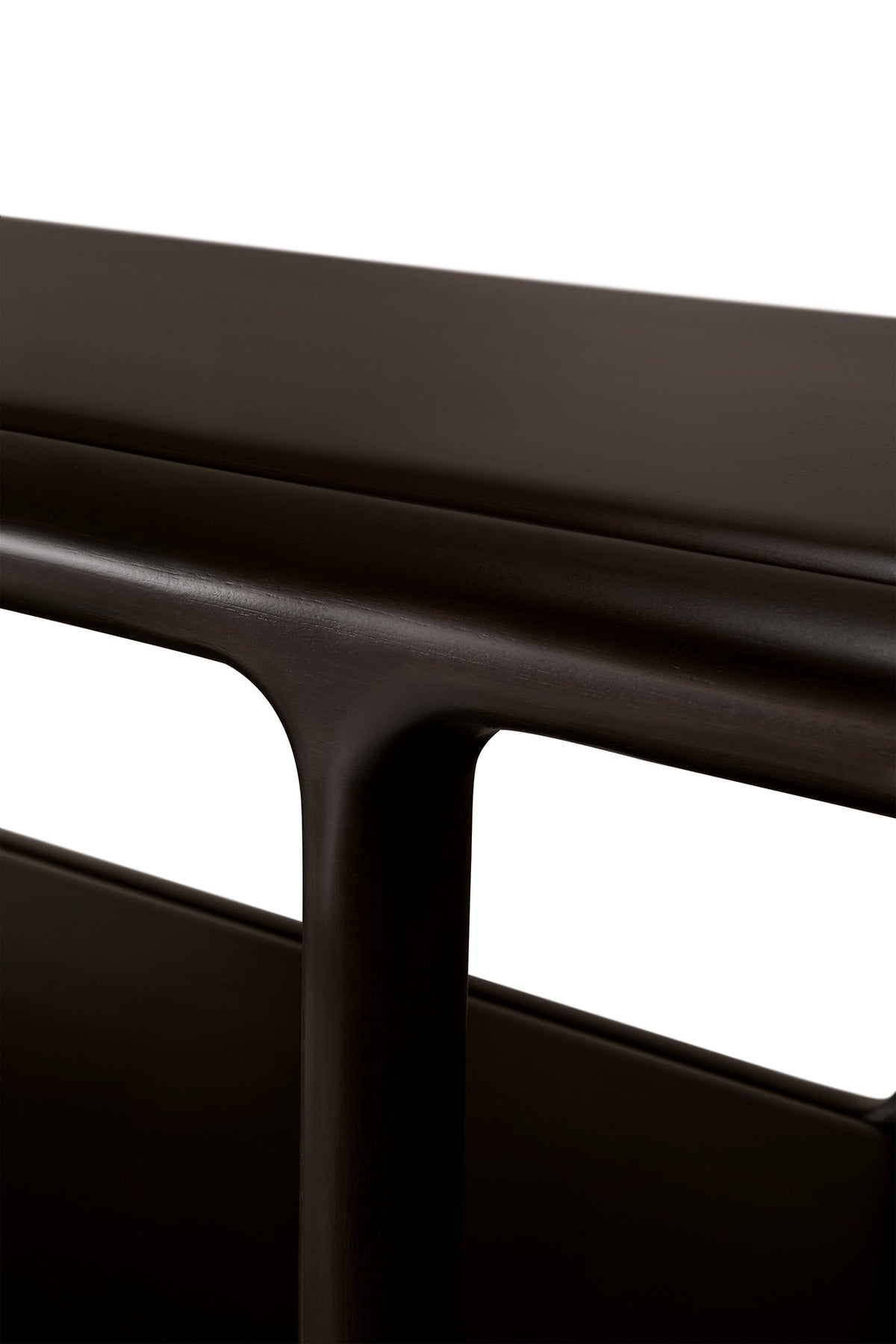 Close-up of a dark brown Eda Console | Wide showing the curved edge of the top surface and a rounded support leg.